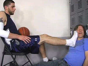 Баскетболист после тренировки облизывает ступни друга